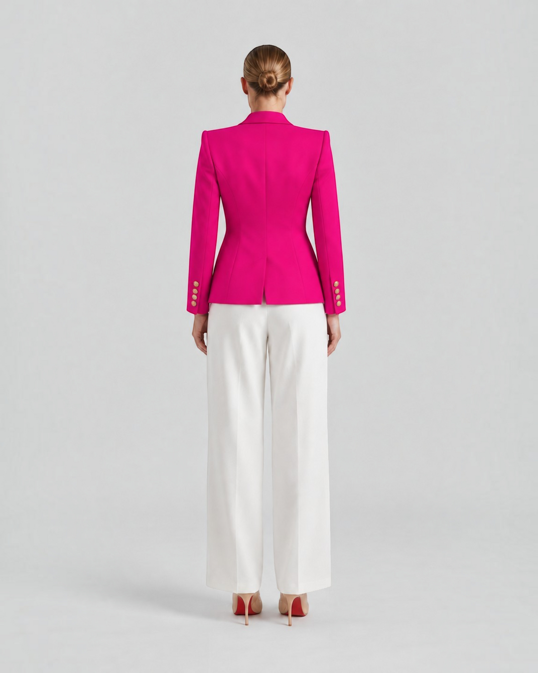 Luna Moda Paolina structured fuchsia blazer with gold decorative buttons, back view on a model with white trousers.