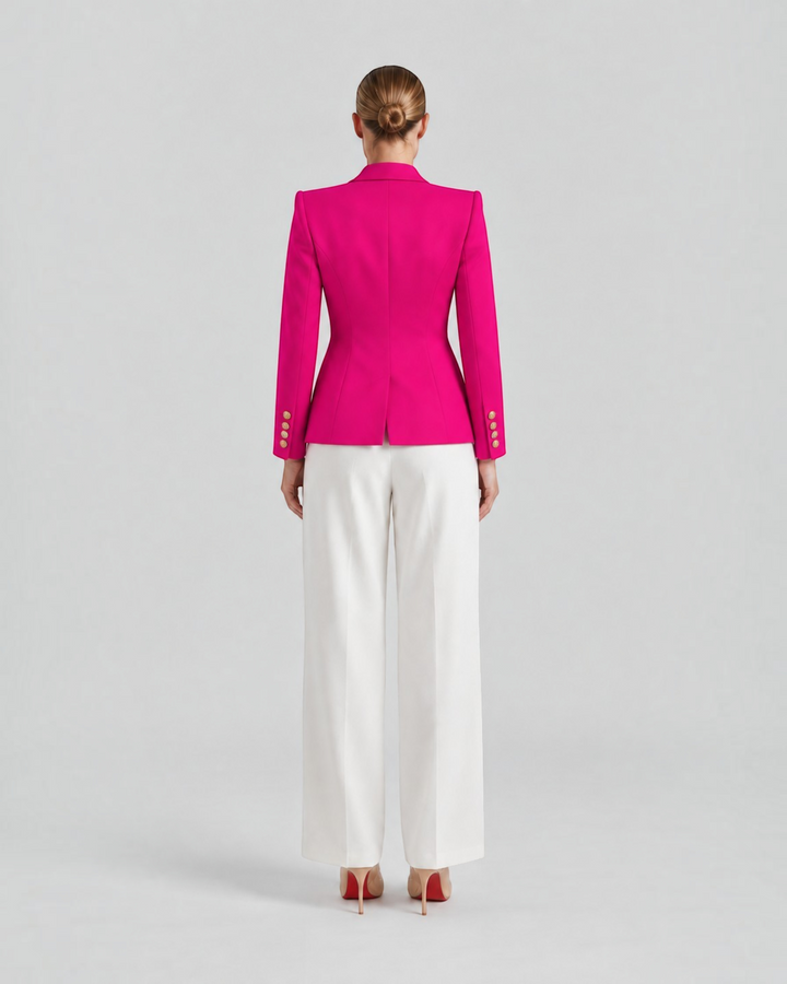 Luna Moda Paolina structured fuchsia blazer with gold decorative buttons, back view on a model with white trousers.