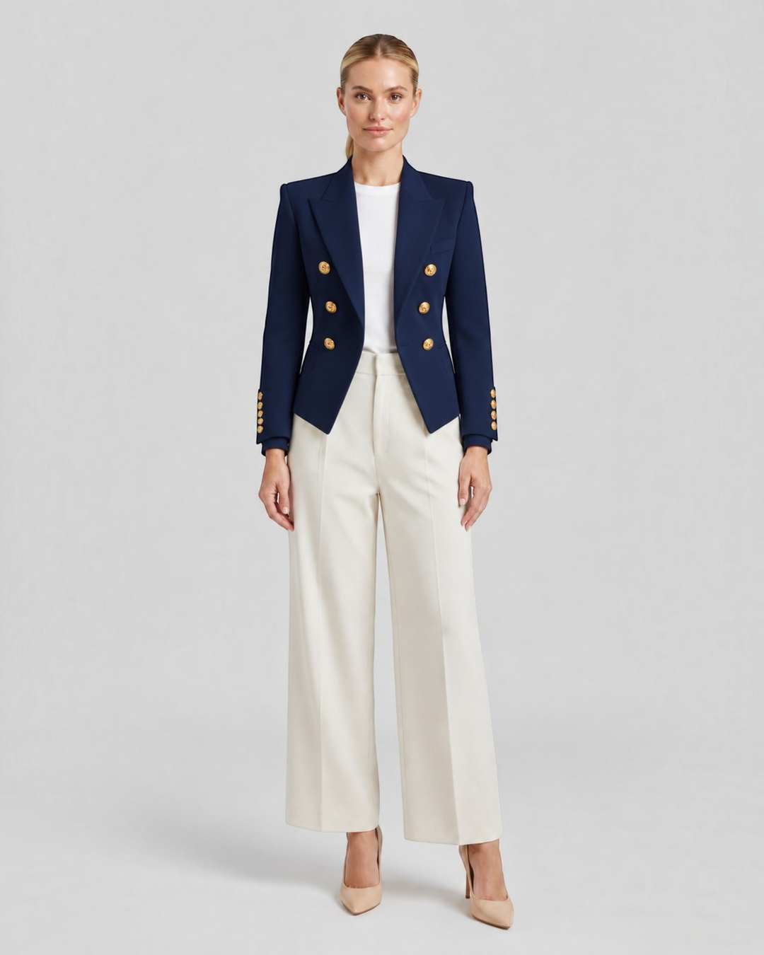 Luna Moda Paolina navy blue structured blazer with gold decorative buttons worn by a model with white trousers