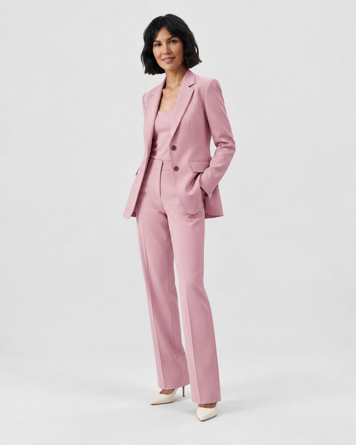 Luna Moda pink structured blazer and tailored trouser suit worn by a woman with white heels on a light background.