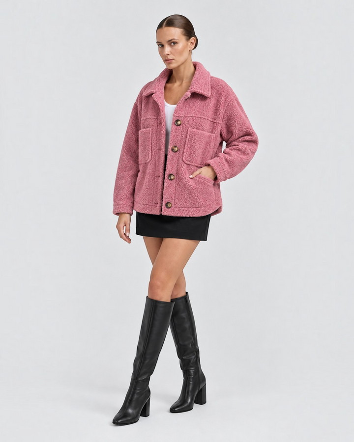 Luna Moda pink teddy fleece short jacket with lapels, front buttons, and pockets worn by a model with black boots.