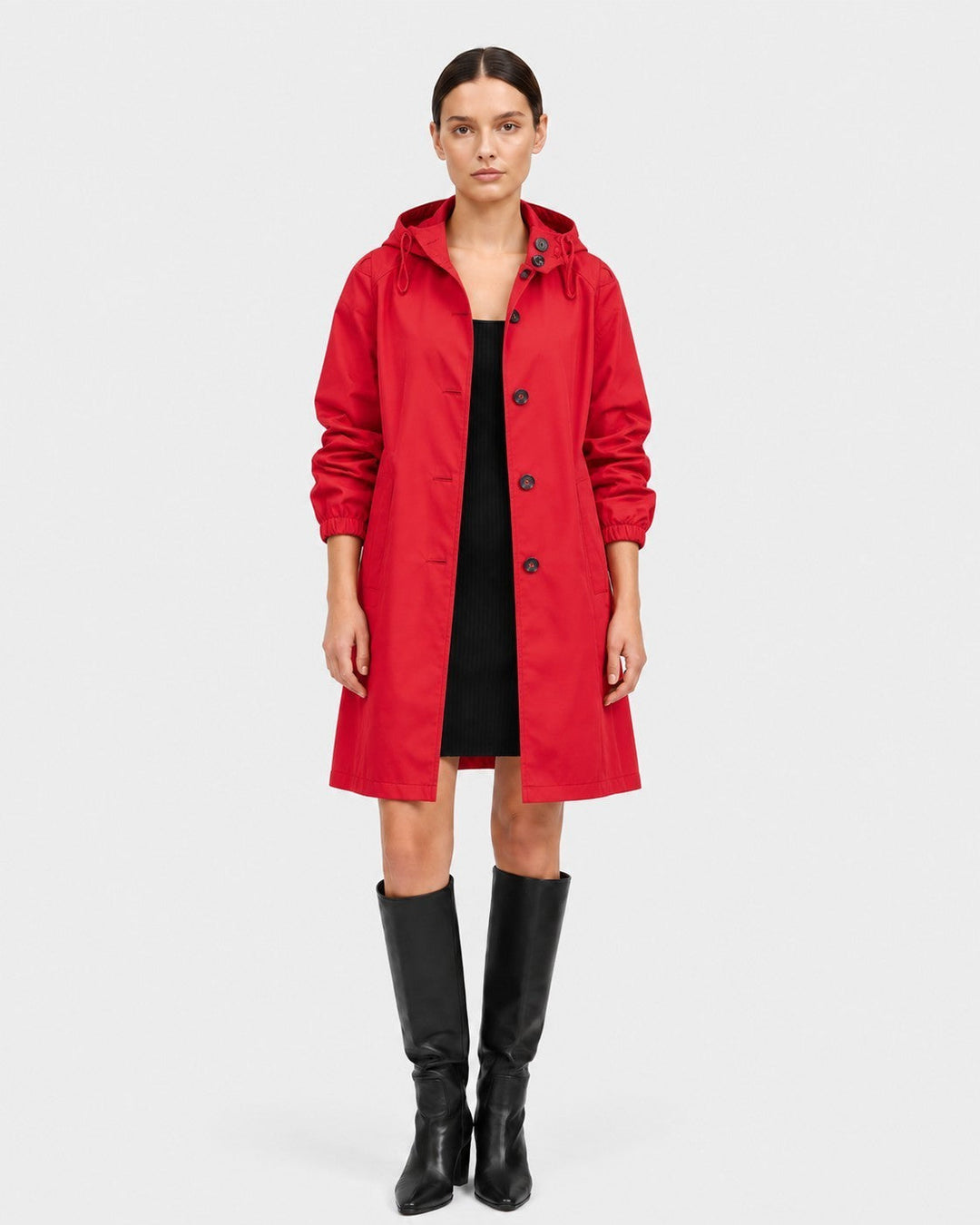Luna Moda red oversized waterproof raincoat with a hood and button closure worn by a model with black boots