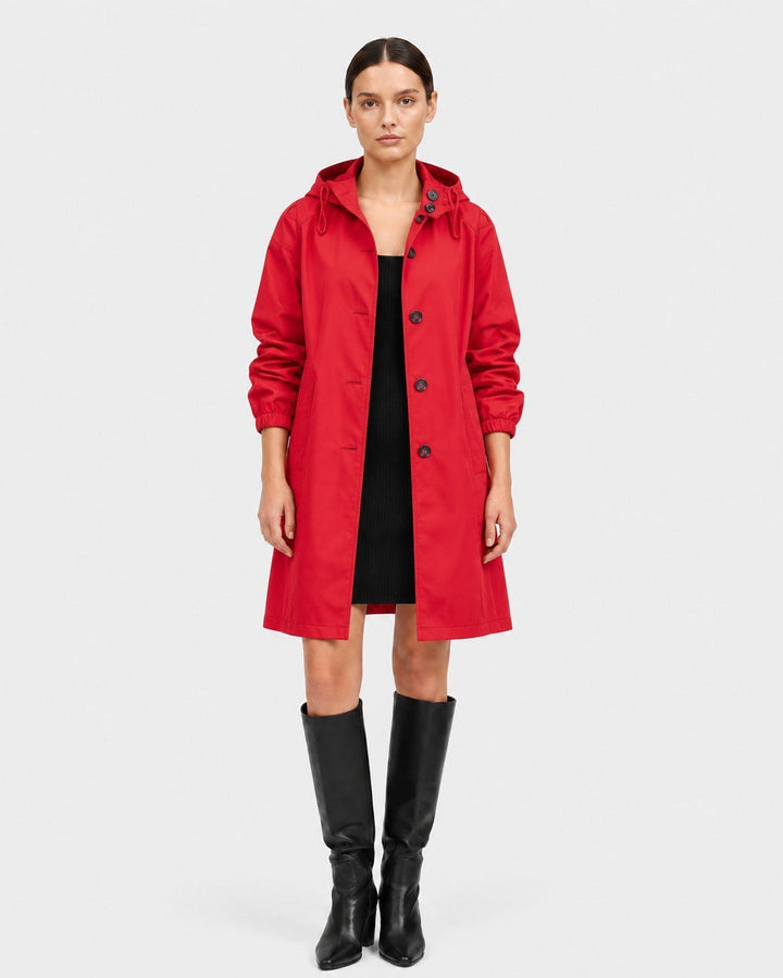 Luna Moda red oversized waterproof raincoat with a hood and button closure worn by a model with black boots