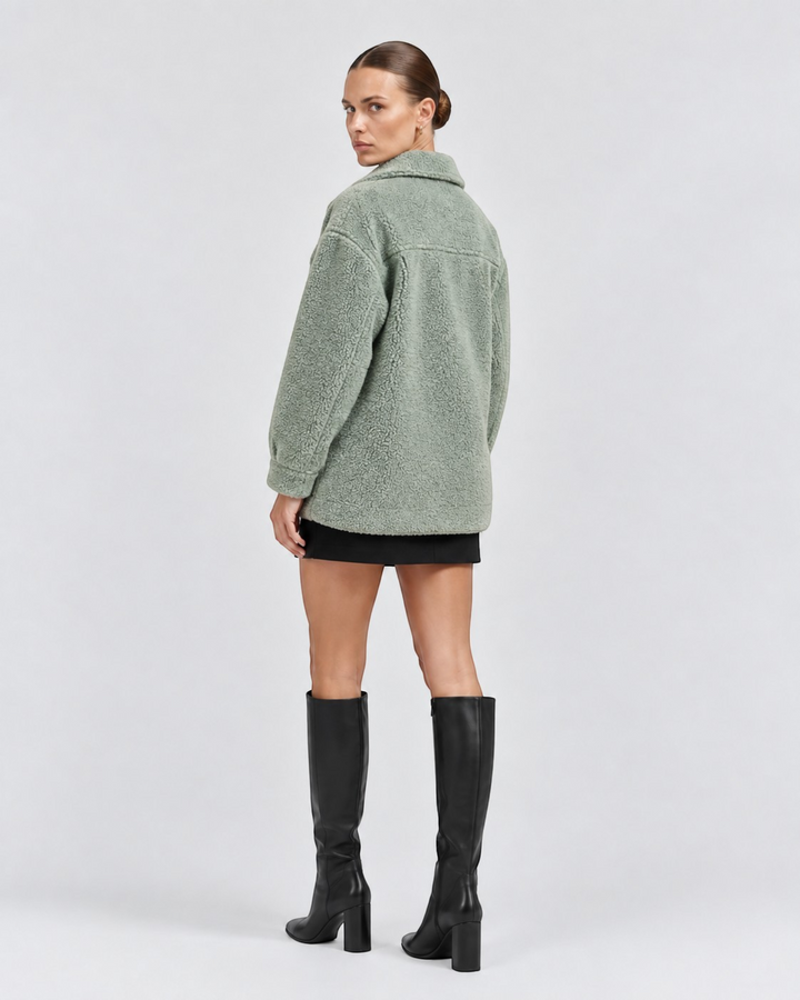 Luna Moda sage green teddy fleece jacket with collar, worn by a model with black skirt and high boots, back view