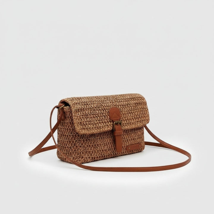 Luna Moda Serena woven crossbody bag in brown with a flap closure, adjustable strap, and elegant summer style.