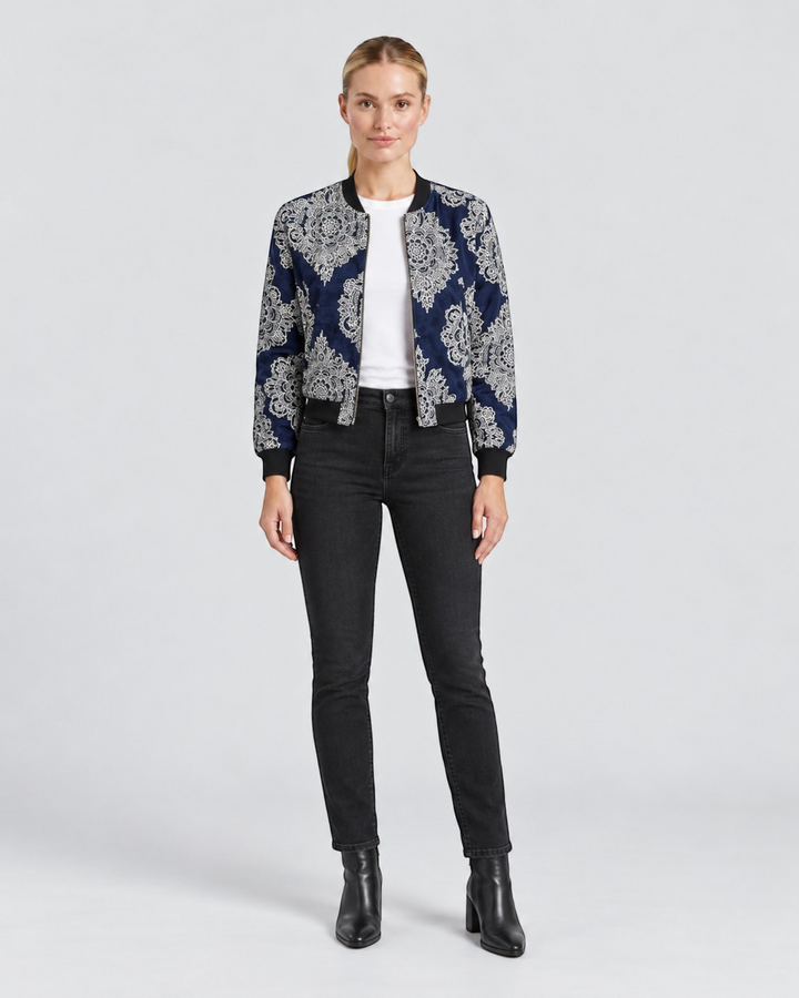 Luna Moda Sofia bomber jacket in navy blue with a white botanical pattern, worn with black jeans and ankle boots.