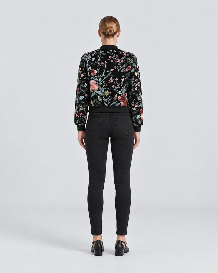 Luna Moda Sofia bomber jacket with black base and colorful botanical floral print worn with black jeans, back view