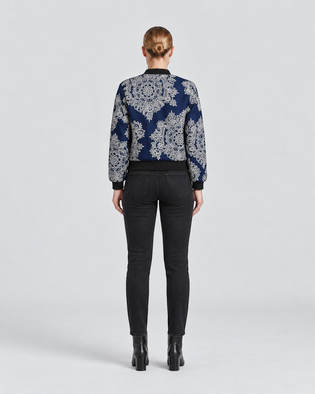 Luna Moda Sofia bomber jacket with blue and white botanical print, black ribbed trim, worn with black jeans, back view