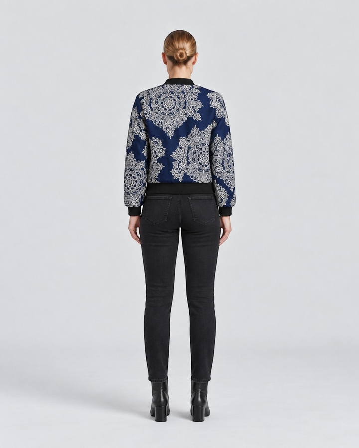 Luna Moda Sofia bomber jacket with blue and white botanical print, black ribbed trim, worn with black jeans, back view