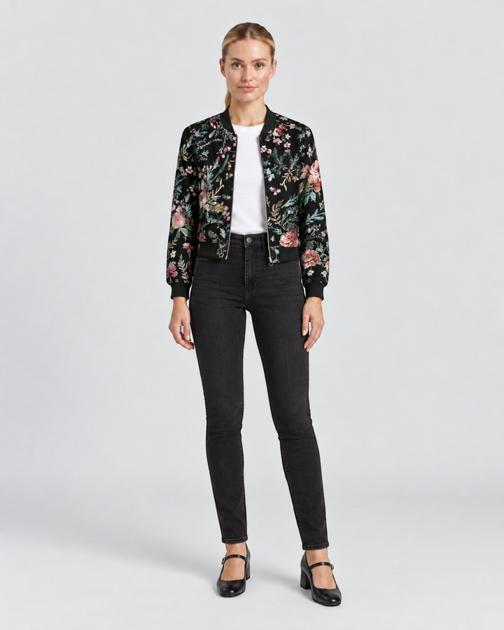 Luna Moda Sofia bomber jacket with black base and colorful botanical floral print worn by a woman with black jeans