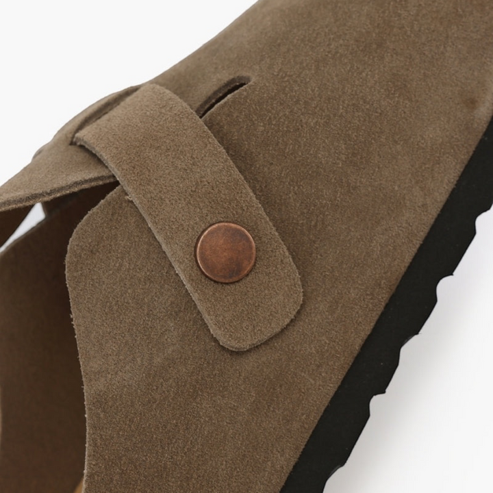 Luna Moda Sebastian taupe suede clogs featuring delicate stitching and a metallic side button detail