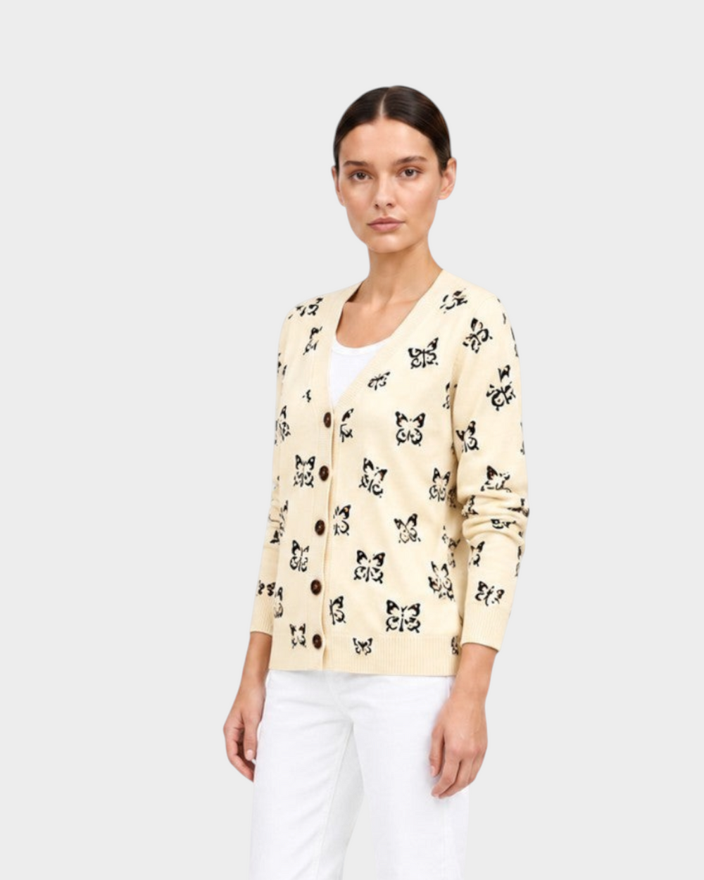 Luna Moda Teresa cardigan in cream with black butterfly print, worn over a white top and white jeans.