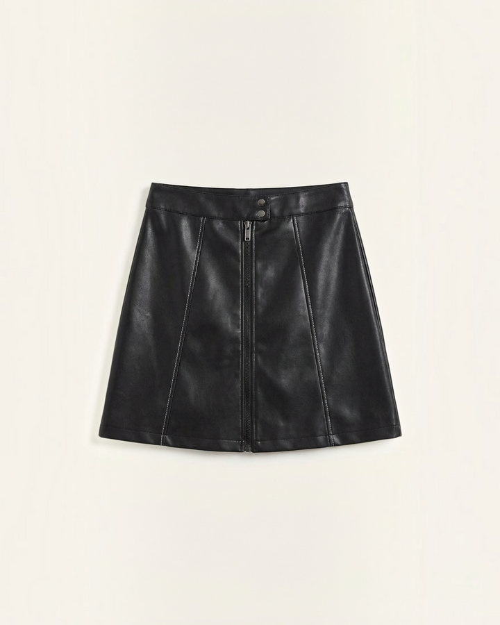 Luna Moda Edda black vegan leather mini skirt with a front zipper, high waist, and architectural panel stitching.