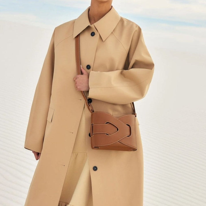 Luna Moda Vera tan Spanish leather crossbody bag with magnetic closure worn by a model in a beige trench coat