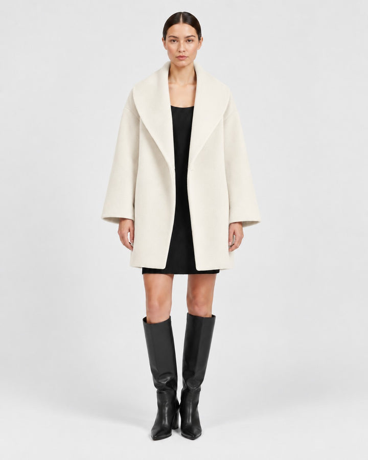 Luna Moda Veronika cream wool-blend coat with wide lapels worn by a model with a black dress and knee-high boots