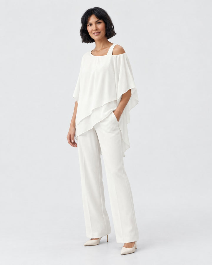 Luna Moda white chiffon two-piece set featuring a modern cold-shoulder layered top and tailored trousers on a model