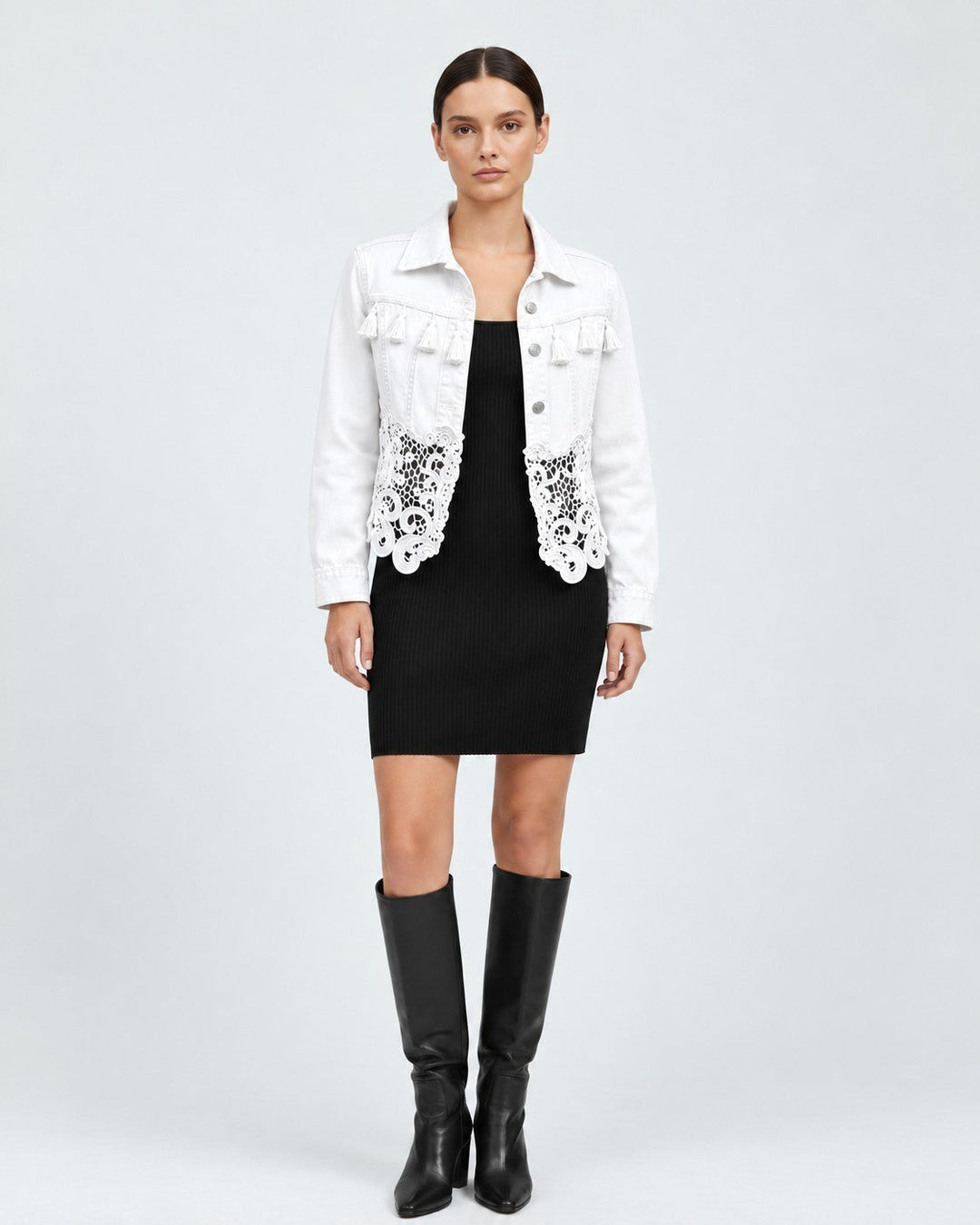 Luna Moda white denim jacket featuring fringe details on the chest and an elegant lace hem worn over a black dress.