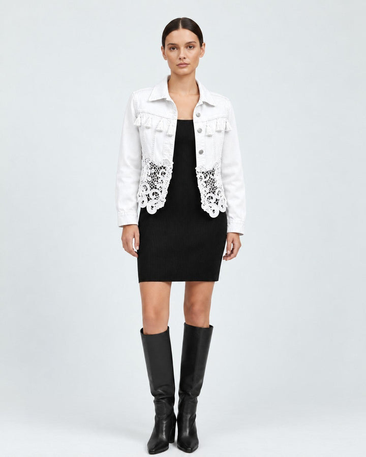 Luna Moda white denim jacket featuring fringe details on the chest and an elegant lace hem worn over a black dress.