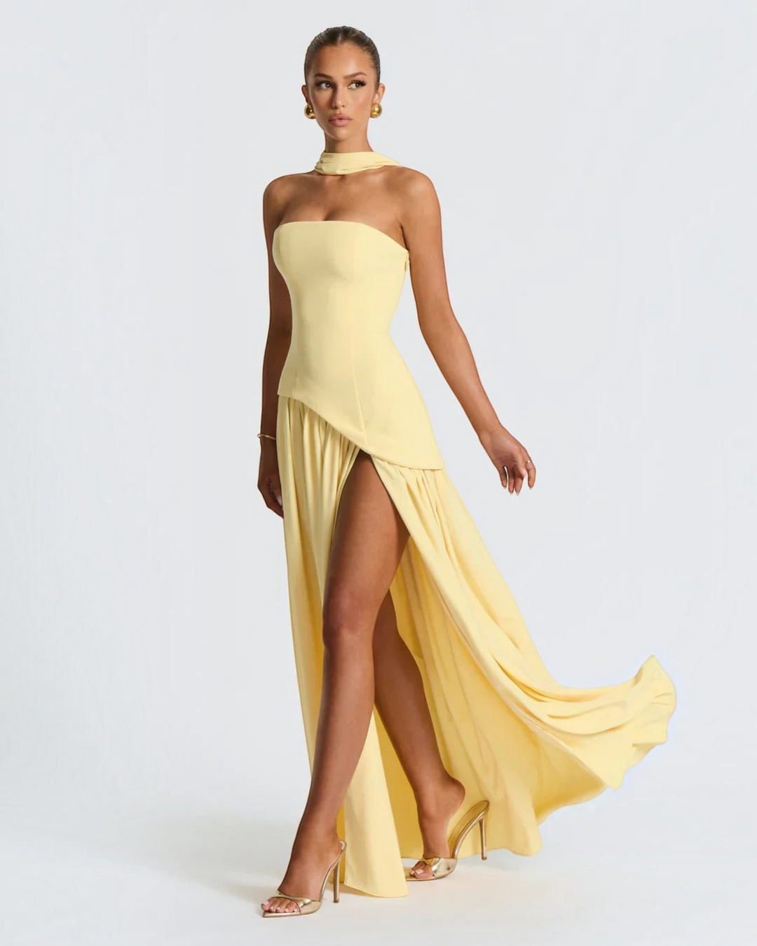 Luna Moda Zadie yellow maxi dress with halter neck, open back, and high side slit worn by a model