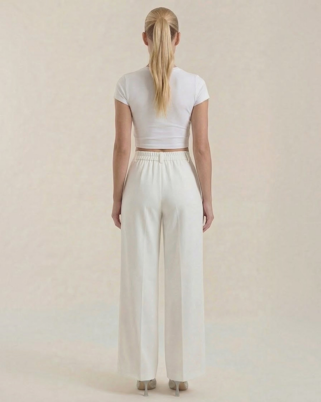 Luna Moda high-waisted white palazzo trousers with a fluid wide-leg fit, worn by a woman from the back view.