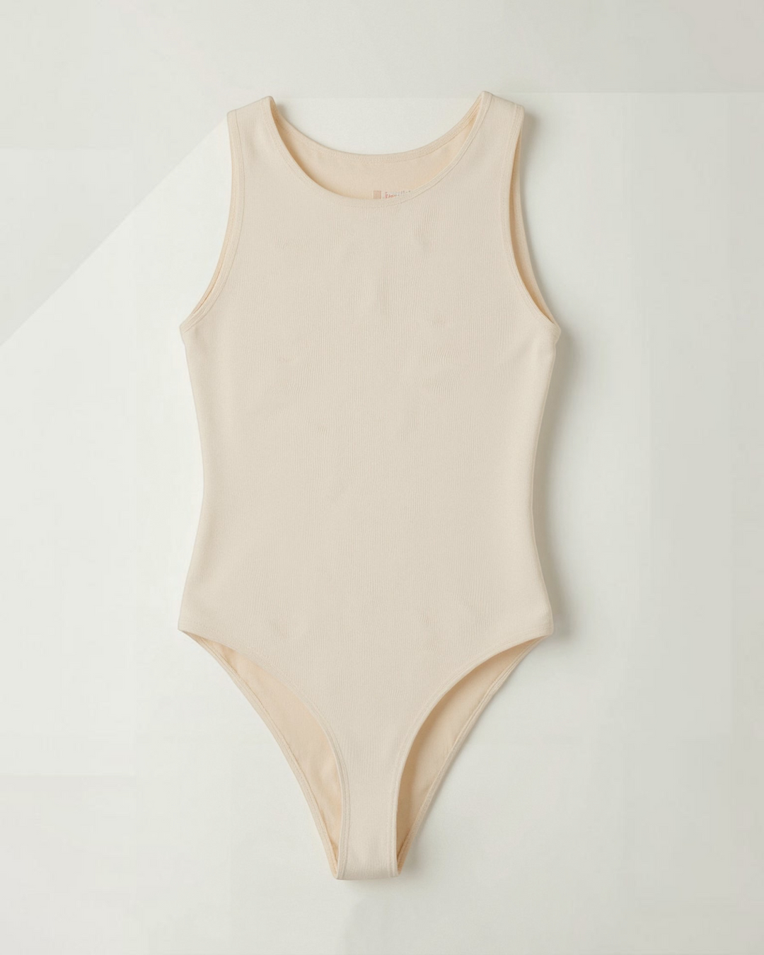 Luna Moda beige seamless thong bodysuit with a round neckline and sleeveless design for a smooth silhouette.