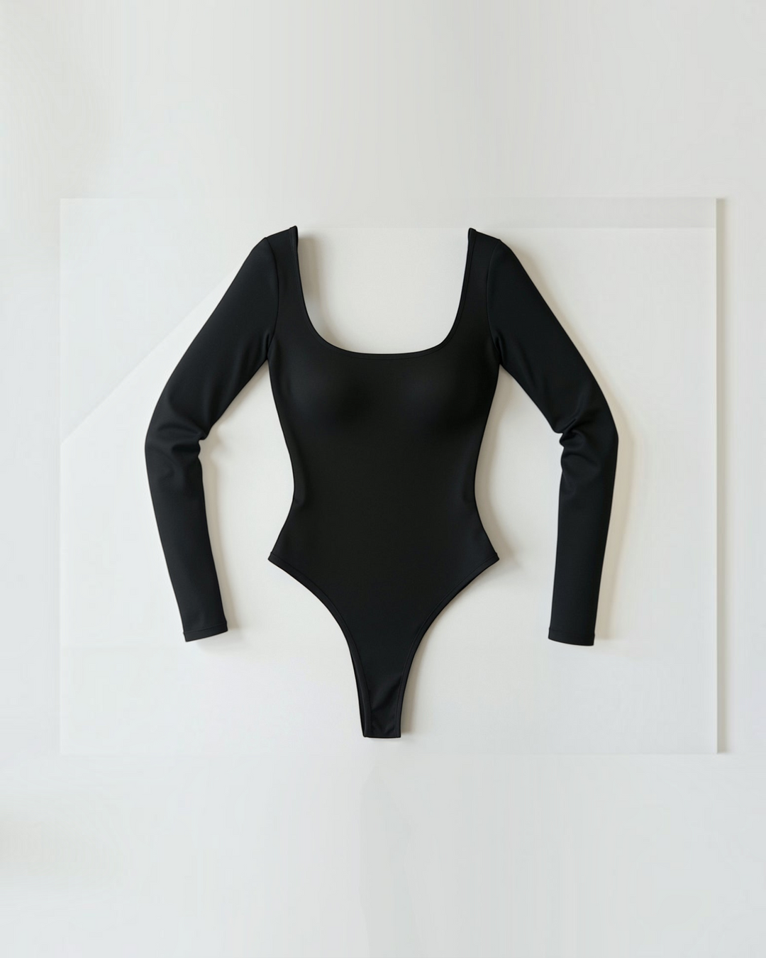Luna Moda black seamless long-sleeve thong bodysuit with a scoop neckline and ultra-thin compressive fabric.