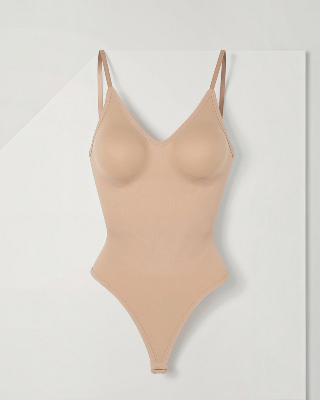 Luna Moda seamless beige shaping bodysuit with V-neck, thin straps, and low back design for a smooth silhouette.