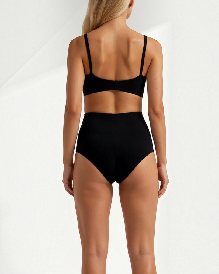 Luna Moda black seamless mid-waist shaping briefs with ribbed texture worn by a blonde model from the back view.