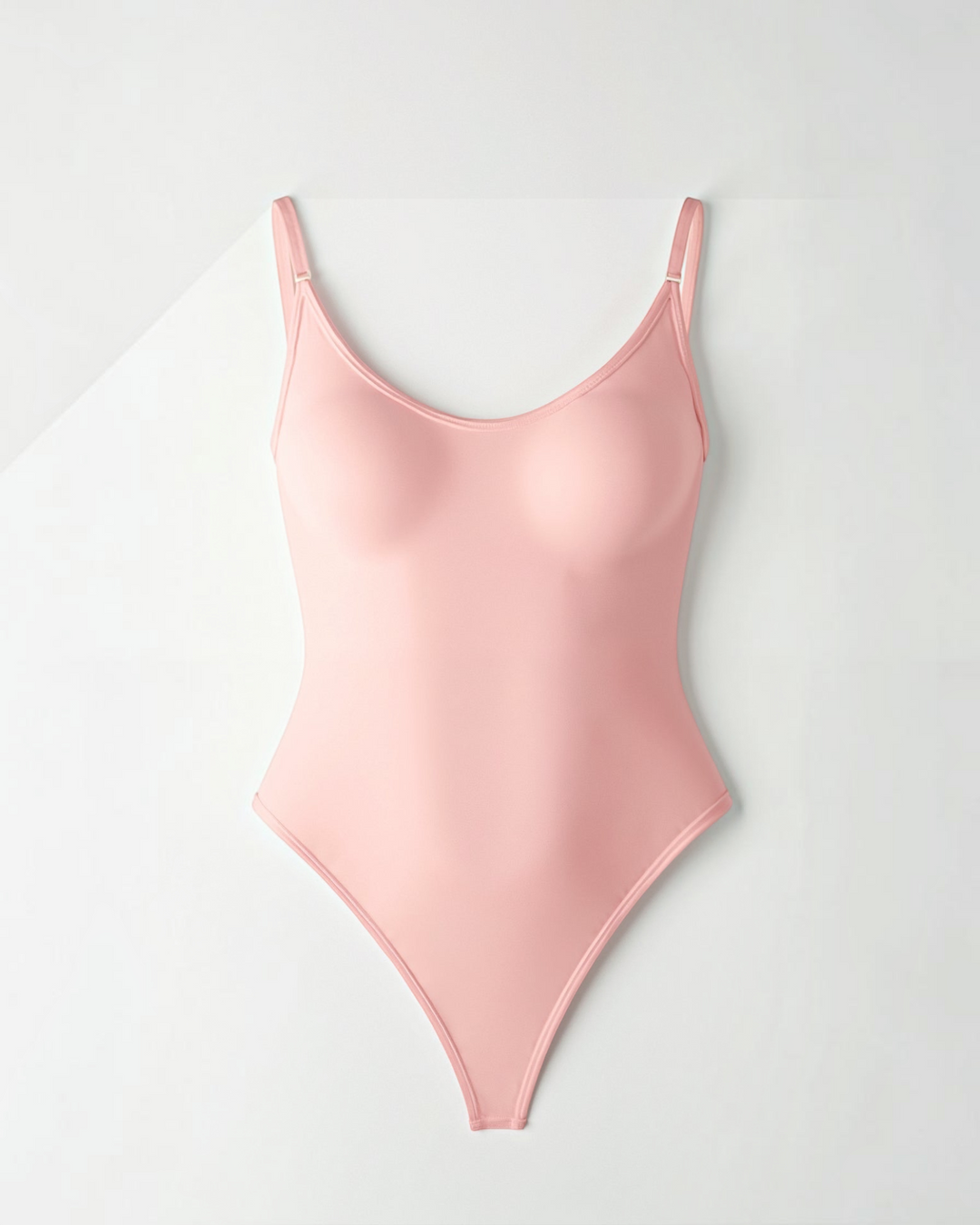 Luna Moda Snatched thong bodysuit in light pink with a boat neckline, adjustable straps, and smoothing fabric.