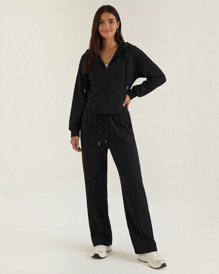 Luna Moda black two-piece lounge set featuring a zip-up hoodie and wide-leg trousers worn by a smiling model